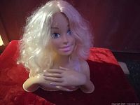 Front view of Barbie styling head showing face, hair, and molded hands