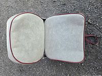 top view of open grey vinyl boat seat with red piping