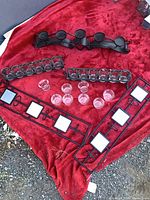All candle holders and glass cups displayed on red fabric