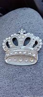 Front view of crown-shaped silver-tone rhinestone belt buckle