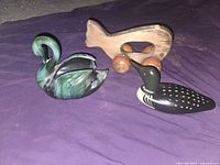 Three items grouped: ceramic swan, wooden loon, wooden massager