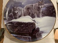 Front view of plate showing wolves in snowy mountain landscape with gold rim