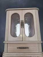 Front view closed showing glass doors and drawer