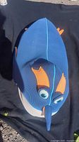 Front view of blue and orange mesh penguin water toy on black background