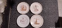Front view of all four commemorative plates showing church designs and gold rims