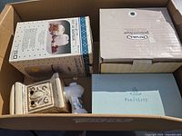Box containing several boxed warmers and candle holders