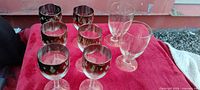 Group of eight stemmed glasses showing six gilt-rim snowflake pieces and two plain pieces
