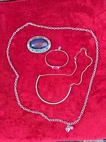 All four jewellery pieces on red fabric