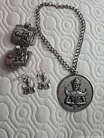 Bracelet, both earrings and unattested necklace visible; focus on entire set