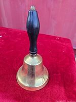 Full view of brass hand bell standing upright