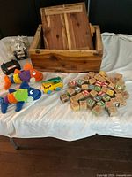 Wide shot of all items including wooden box, blocks, toys and remote control car