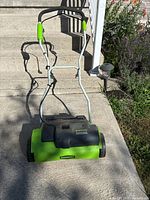 Front view of the Greenworks 14-inch electric dethatcher showing the handle and body of the machine.