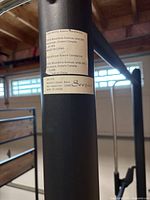 Close up photo of squat rack label showing brand Soozier, model AR1-018, max capacity 1200 lbs, made in China.