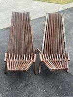 Top view of two wooden folding chairs placed side by side showing ergonomic slat design of seat and tall backrests