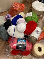 Pile of assorted yarn balls and skeins in various colours