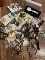 Overall lot showing wristwatches, brooches, bracelets, earrings and boxed Avon watch