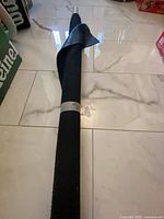 Full length of rolled faux leather bolt on floor, secured with tape