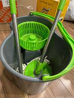 Overall view of spin mop bucket with two handle sections and spinner basket