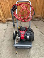 Front view of gas pressure washer with hose and wand