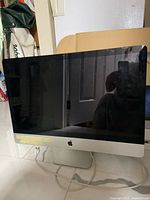 Front view of 27-inch Apple iMac with screen off, power cable visible