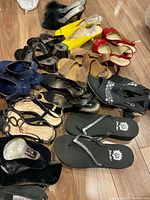 Pile of nine pairs of women’s shoes of various styles and colours