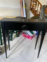 Full view of black narrow side table showing overall structure and legs