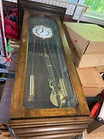 Full view of clock in wooden case with glass door
