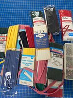 Group of bias tape packages various colours and brands on cutting mat