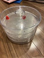 Overall view of clear plastic BioSnacky sprouter with three trays and lid