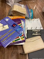 Group shot showing wallet, file folders box, business cards pack, paper bags, zipper bags, peg panel, clipboard
