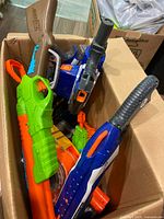 Box containing multiple Nerf and X-Shot blasters