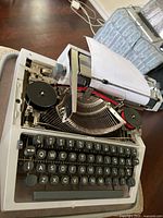 Top view of Commodore typewriter showing keys, ribbon spools, carriage with paper