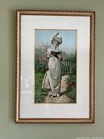 Full framed print showing the full image of the Victorian lady in a garden with decorative gold tone wooden frame and white mat.