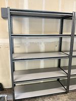 Full front view of heavy duty steel garage shelving with laminate wood shelf toppers, showing five shelving levels.