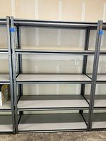 Full view of heavy duty steel garage shelving unit against a wall with multiple shelves, showing shelving structure and surface.
