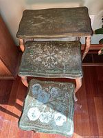 Full view of the three nested tables showing size and surface detail with distressed gold Renaissance pattern