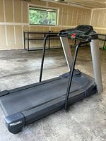 Precor treadmill model M9.31 standing in garage with visible running belt and frame.