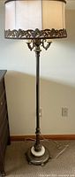 Full view of the vintage floor lamp showing full height and shade with rosette braid trim.