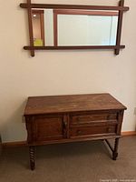 Front view of vintage walnut cabinet with spiral legs and decorative metal handles, showing overall condition and surface wear.