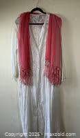 Full view of white sheer embroidered nightgown with a pastel pink scarf draped over it on a black hanger