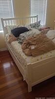 Full view of white wood bed with bedding in room