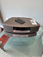 Front view of Bose Wave Music System stacked on 3-disc changer with remote on top