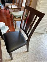 Front angle of single chair showing vinyl seat and slat back