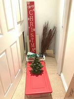 Ceramic tree on red bin lid, wood sign, crate, additional décor visible