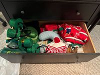 Drawer showing green St. Patrick’s Day hats, Canada toque and scarf, cowboy hat and other accessories