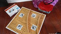Overall lot showing wooden peg board, curved rails, card tray box, plastic bin of game pieces, and purple tote