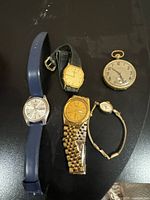 Group image of pocket watch and four wristwatches