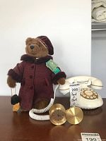 Bear, phone, swivel clock displayed on surface