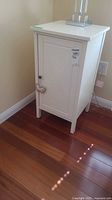 Full view of white nightstand showing door and knob