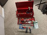 Toolbox open with tray showing tools inside and additional tools laid out in front